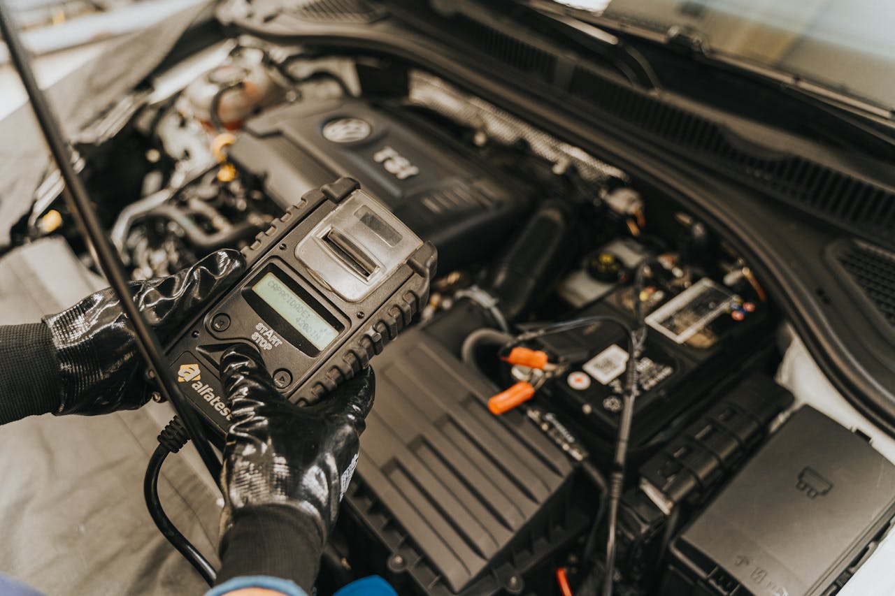 about-us Mechanic diagnosing a car engine with a diagnostic tool, showcasing technical expertise and automotive care.